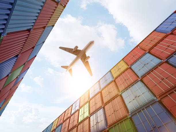 Airplane flying above stacked containers in yard, showing multimodal transport connected with LCL shipping.