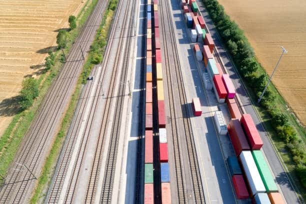 Aerial view of railway tracks with container trains for logistics and supply chain.