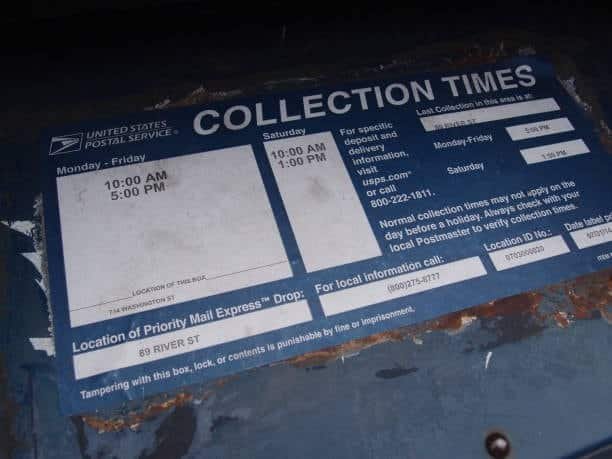 USPS collection times sign showing daily mail pickup schedule.